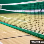 Home 18 배드민턴 네트 규격과 높이 - A detailed close-up image of a professional badminton net setup on an indoor court, showing the net ...